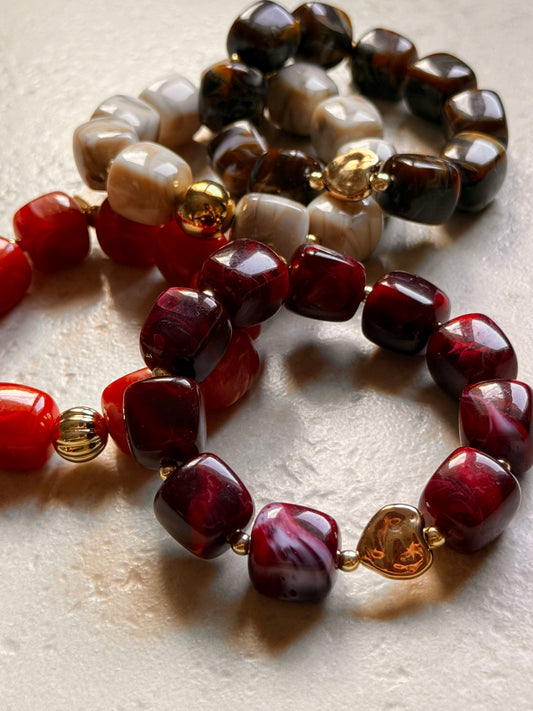 Bracelets élastiques à grosses perles colorées rouge, grenat, moka et crème, avec détails dorés, créés à la main par YourLittleWords.